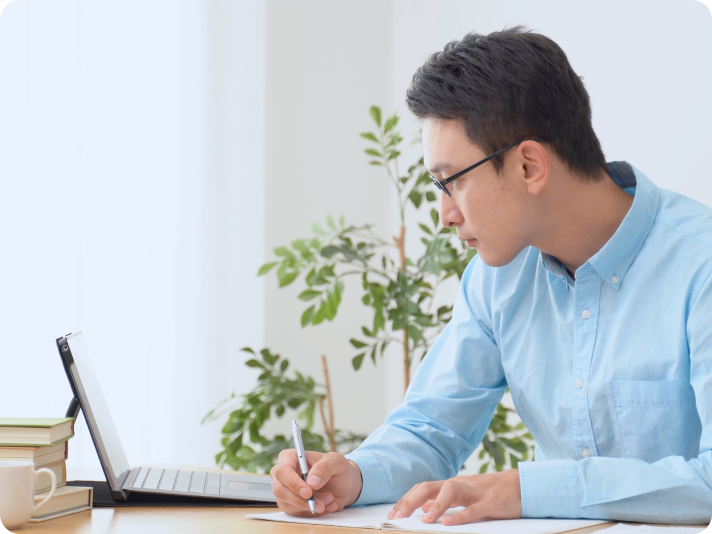 自宅でノートを取りながらオンライン学習をしている受講生